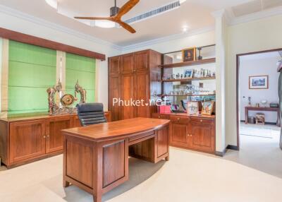 Well-lit home office with wooden furniture and shelving