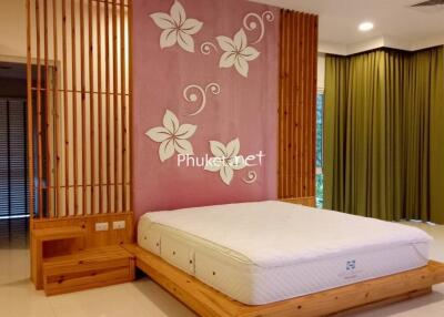 Bedroom with wooden accents and floral wall design