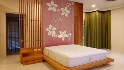 Bedroom with wooden accents and floral wall design