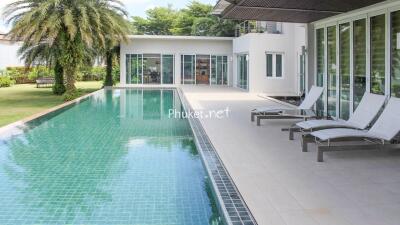 Luxurious outdoor pool area with modern loungers and lush greenery