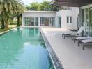 Luxurious outdoor pool area with modern loungers and lush greenery