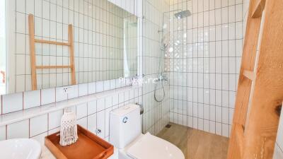 Modern bathroom with a large mirror, toilet, and shower