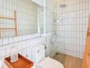 Modern bathroom with a large mirror, toilet, and shower