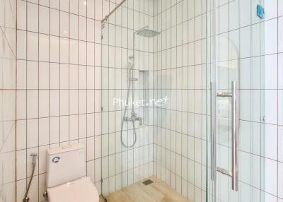 Modern white tile bathroom with shower and toilet