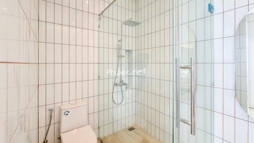 Modern white tile bathroom with shower and toilet