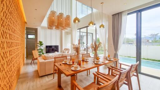 Open living room with dining area featuring large windows and pool view