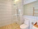 Modern bathroom with glass shower, tiled walls, and wooden accents