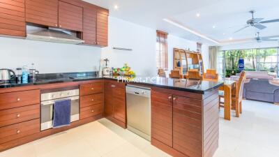 Modern kitchen with wooden cabinetry and dining area