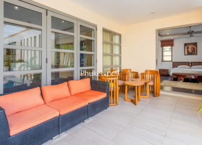 Spacious living area with seating and adjacent bedroom