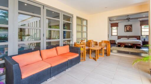 Spacious living area with seating and adjacent bedroom