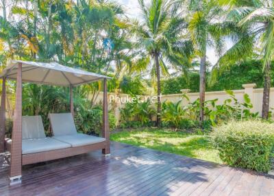 A lush backyard with a covered seating area