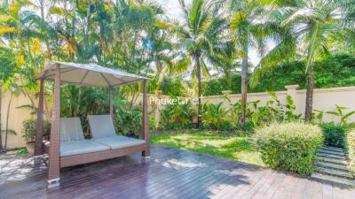 A lush backyard with a covered seating area