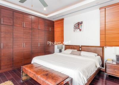 Spacious bedroom with large wooden wardrobes and a stylish bed
