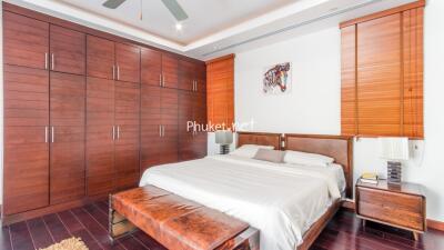 Spacious bedroom with large wooden wardrobes and a stylish bed