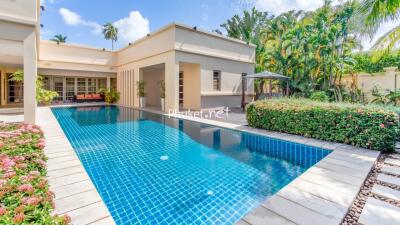 Outdoor area with large swimming pool and lush greenery