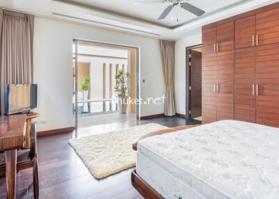 Spacious and bright bedroom with wooden furniture and a large bed