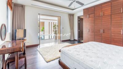 Spacious and bright bedroom with wooden furniture and a large bed