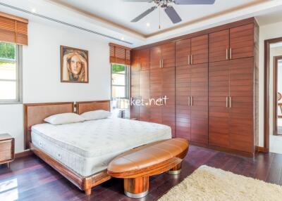 Spacious bedroom with wooden furnishing and ample storage space