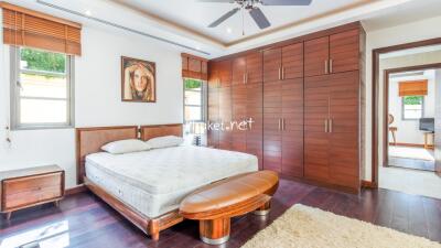 Spacious bedroom with wooden furnishing and ample storage space