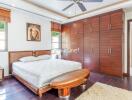 Spacious bedroom with wooden furnishing and ample storage space