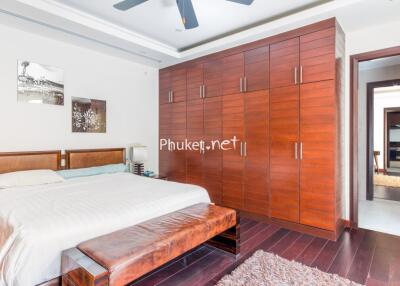 Spacious bedroom with a large wooden wardrobe and a king-sized bed