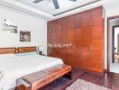 Spacious bedroom with a large wooden wardrobe and a king-sized bed