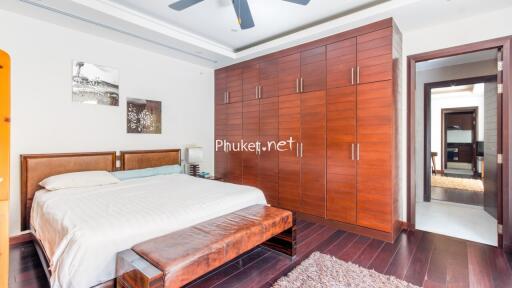 Spacious bedroom with a large wooden wardrobe and a king-sized bed