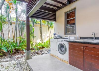 Covered outdoor utility area with washer and dryer