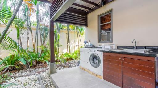 Covered outdoor utility area with washer and dryer