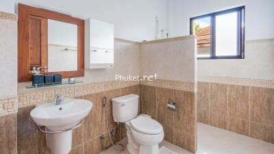 Modern bathroom with sink, toilet, mirror, and wall tiles