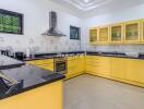 Modern kitchen with yellow cabinets and black countertops