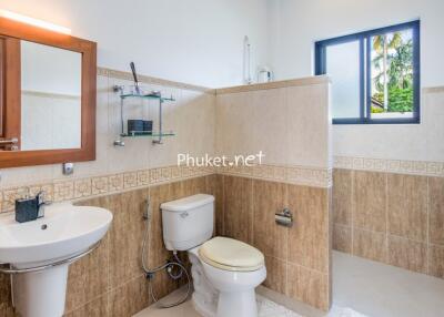 Modern bathroom with sink, toilet, mirror and window