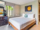 Bedroom with window, wooden bed, and dresser