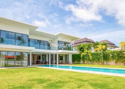 Modern two-story house with large windows, spacious backyard, and pool