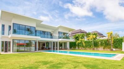 Modern two-story house with large windows, spacious backyard, and pool