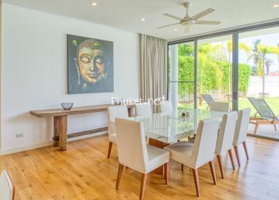 Spacious dining area with a large glass table and a view of the garden