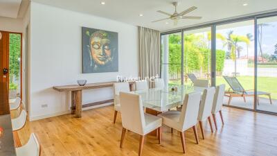 Spacious dining area with a large glass table and a view of the garden