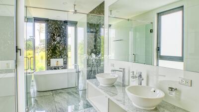 Spacious and modern bathroom with double sinks and a bathtub