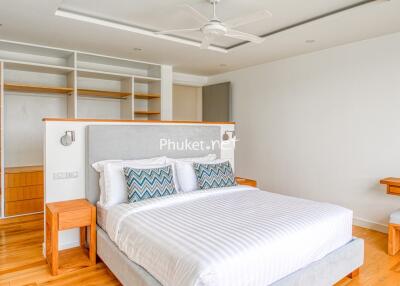 Modern bedroom with large bed, built-in shelves, and wooden flooring