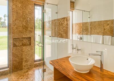 Modern bathroom with wooden countertop and glass shower
