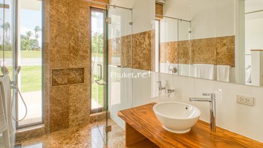 Modern bathroom with wooden countertop and glass shower