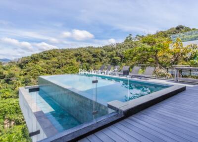 Modern outdoor pool with forested hillside view