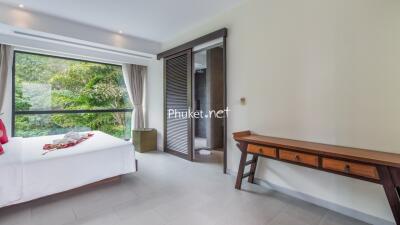 Bedroom with large window and forest view