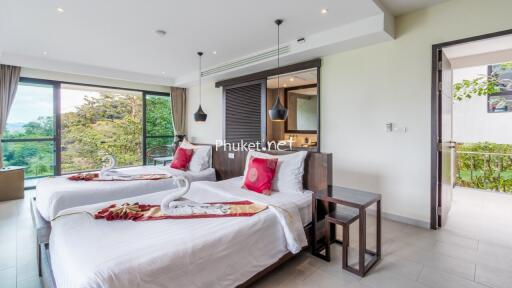 Modern bedroom with two single beds, large windows, and a scenic view.