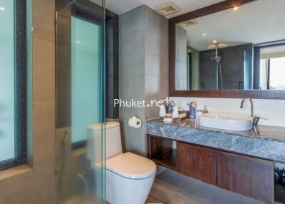 A modern bathroom with a shower, toilet, and sink area