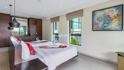 Modern, well-lit bedroom with twin beds and decorative elements