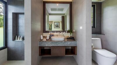 Modern and spacious bathroom with sink, toilet, and mirror