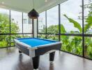 Modern recreation room with pool table and large windows with scenic views