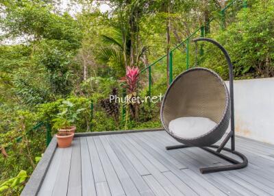 Cozy outdoor seating area with a modern chair overlooking lush greenery