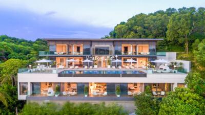 Luxurious multi-story house with spacious outdoor terraces and swimming pool, surrounded by lush greenery.